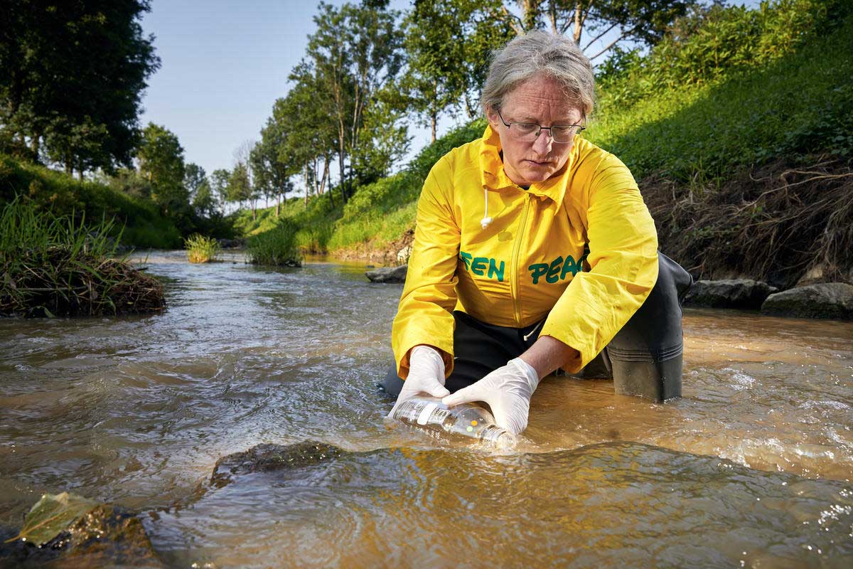 Lo staff di Greenpeace preleva campioni dalle acque di un fiume vicino a uno dei più grandi allevamenti intensivi in Austria.